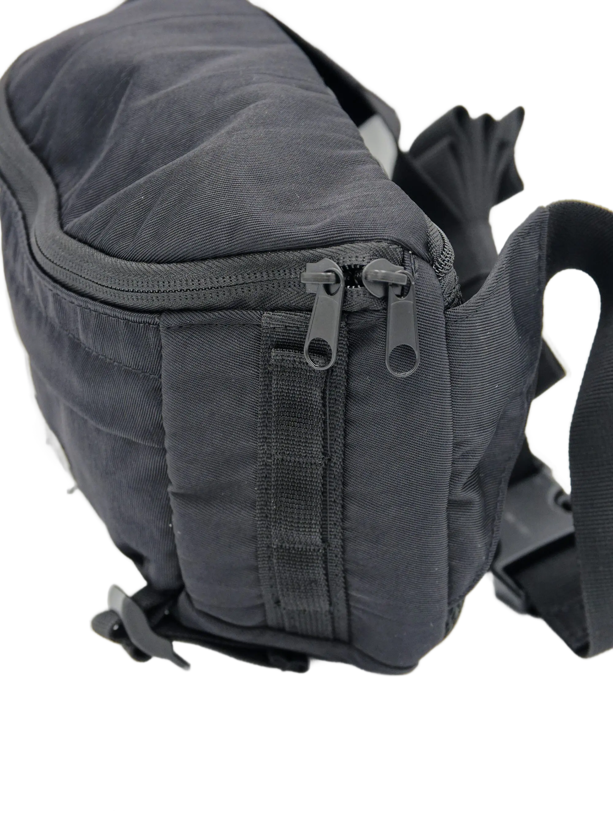 Angled front view of the dark grey nylon waist bag with dual zippered front pockets, pull tabs, and adjustable webbing belt