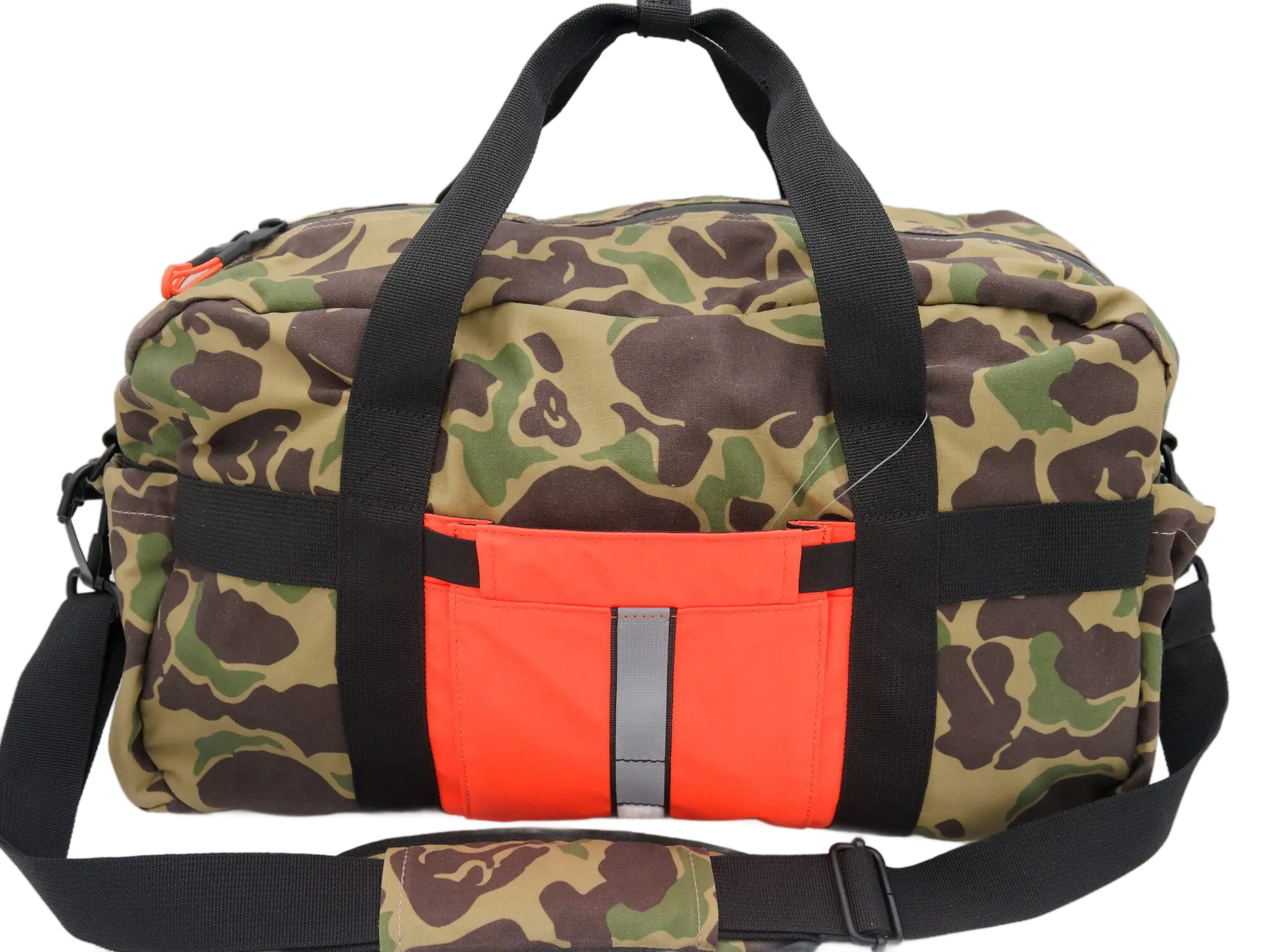 Front view of the camo waxed canvas duffle bag with orange PU front pocket, reflective strip, and padded black handles