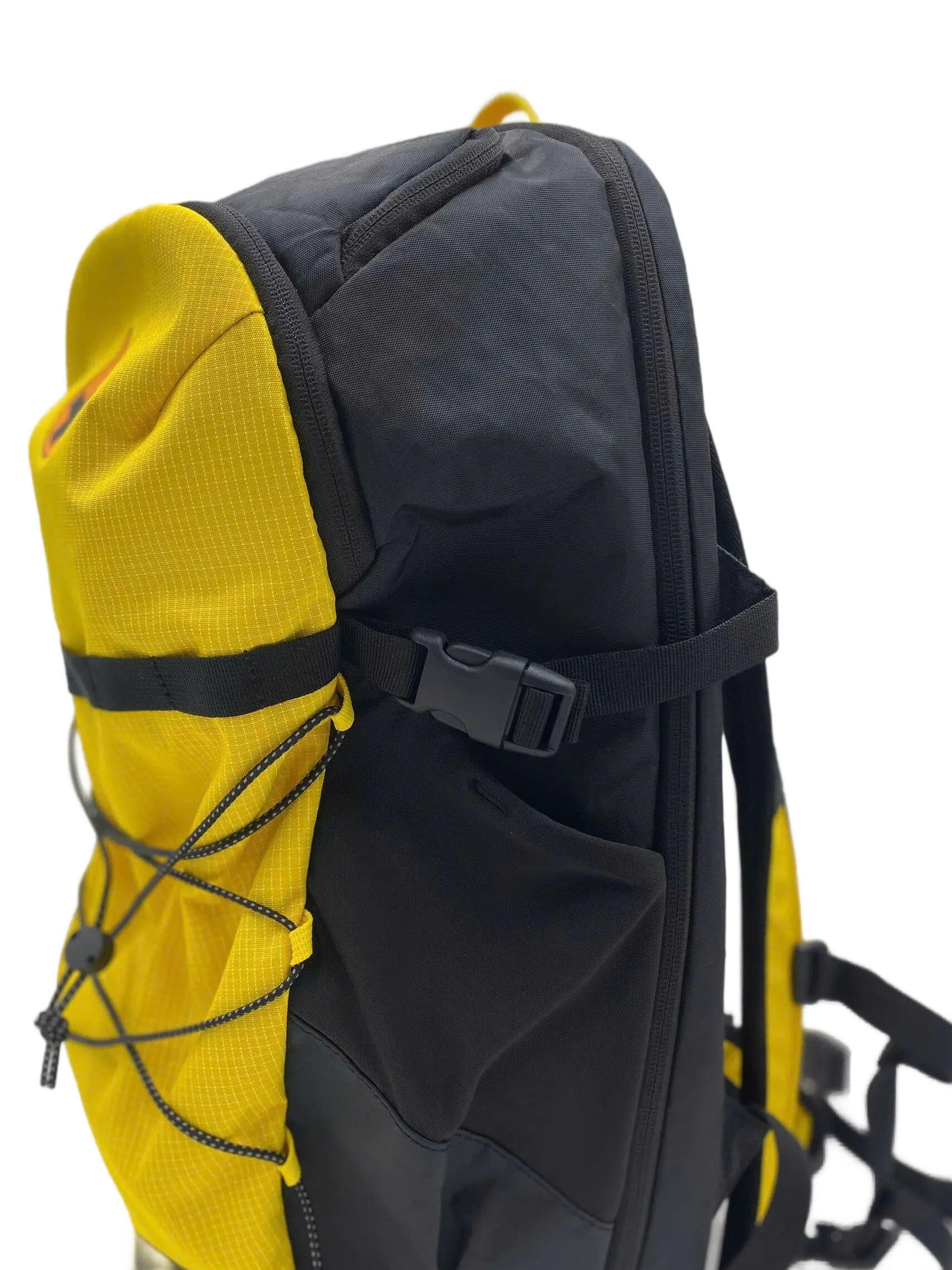 Side view of the golden yellow and black trail backpack showing compression bungee cord, buckle strap, and side pocket