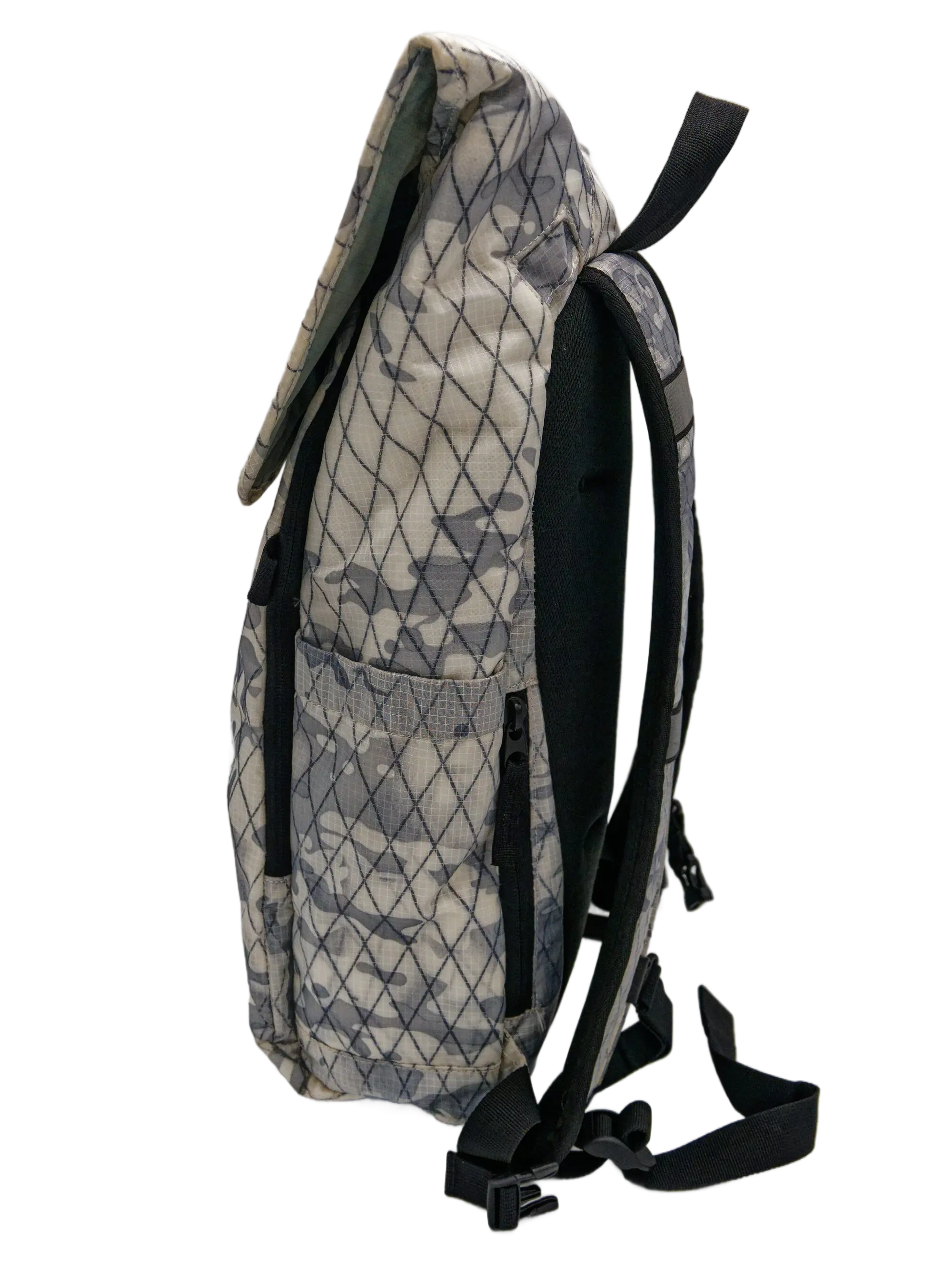 Side profile of the arctic camouflage X-Pac backpack with black padded shoulder strap, a side zip pocket, and roll-top closure