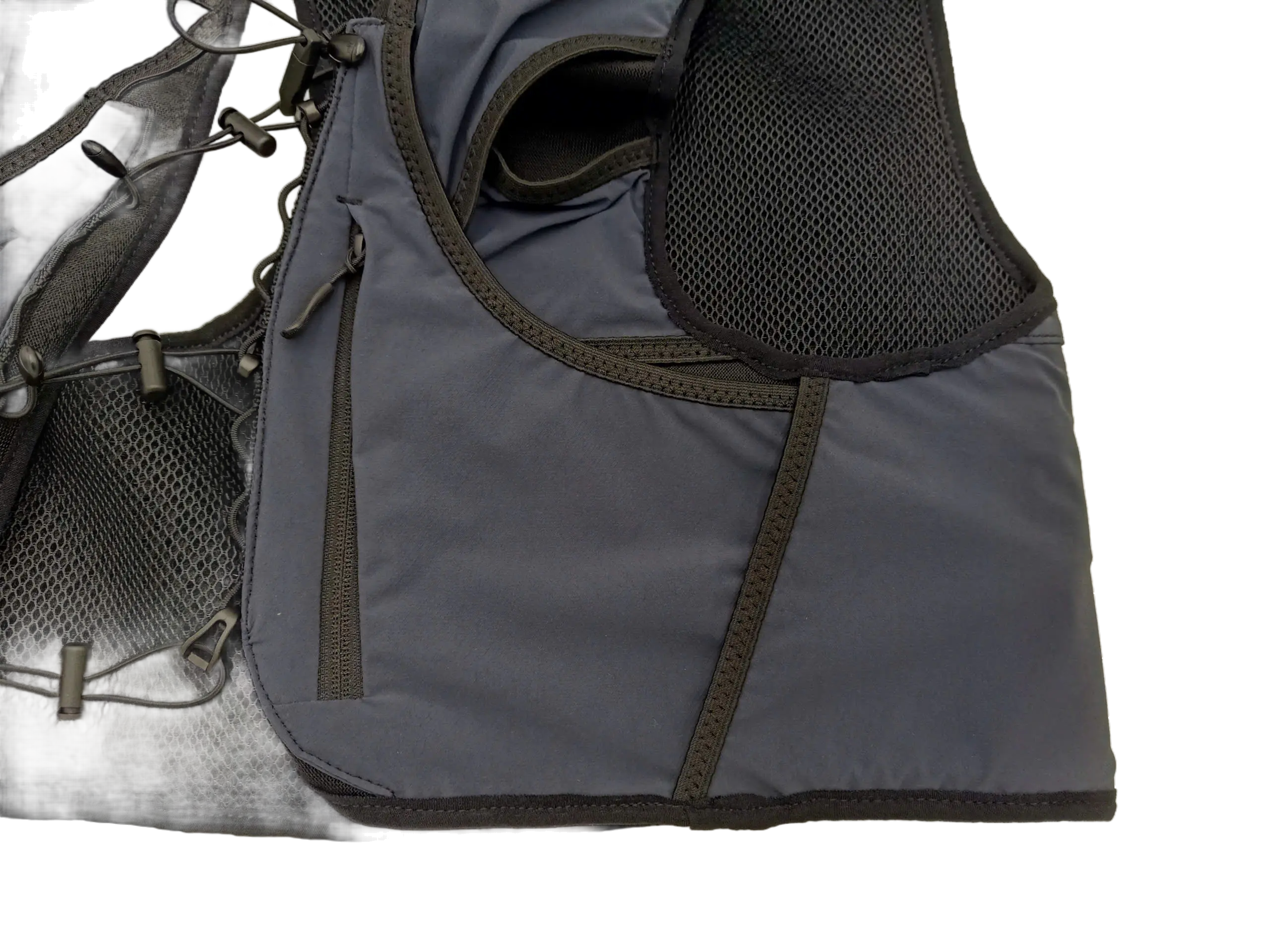 Close-up of the lower front pocket panel showing the zippered compartment and breathable mesh shoulder section