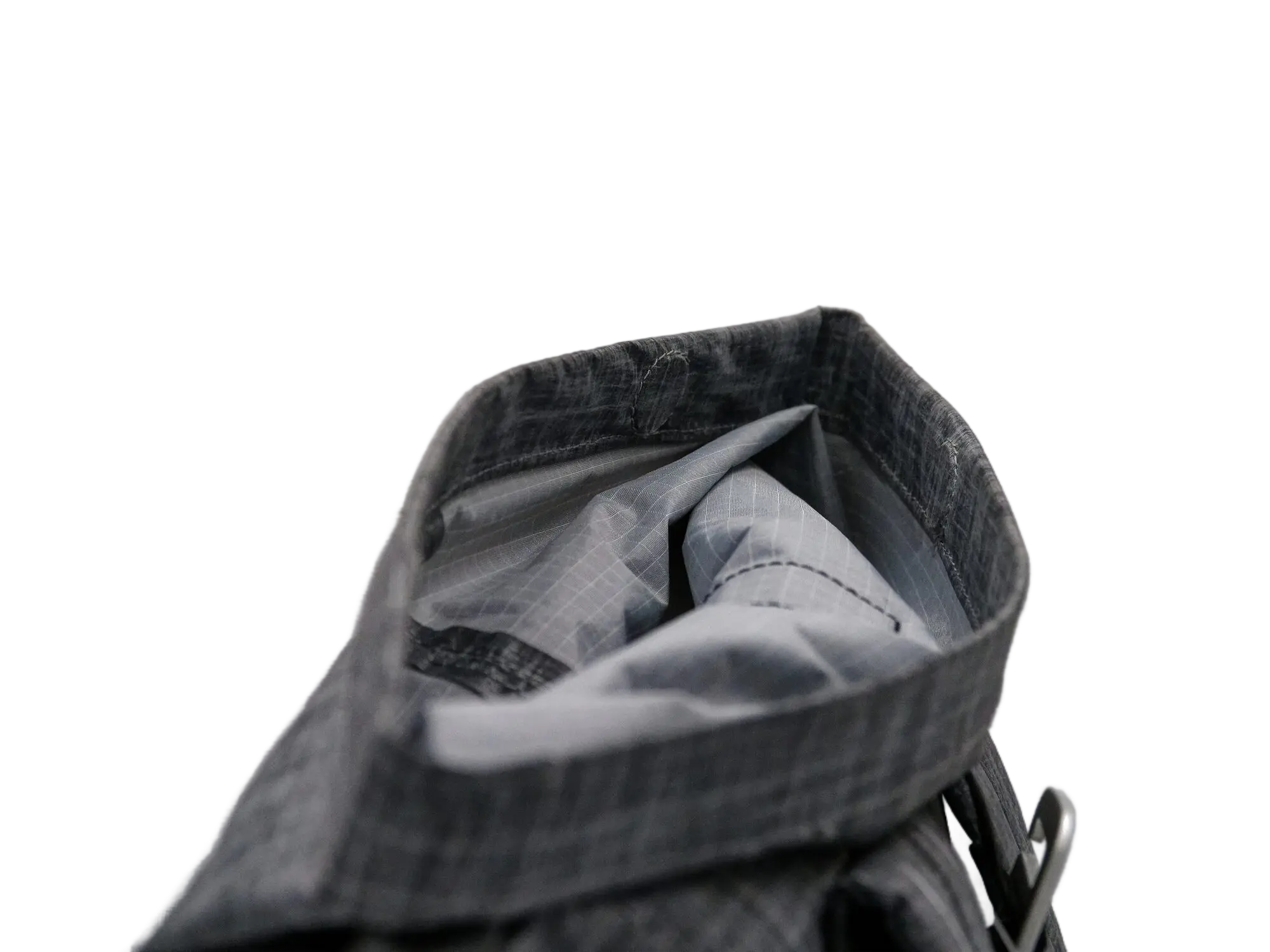 Close-up looking into the open rolltop opening, showing the grey fabric main compartment and an internal sleeve