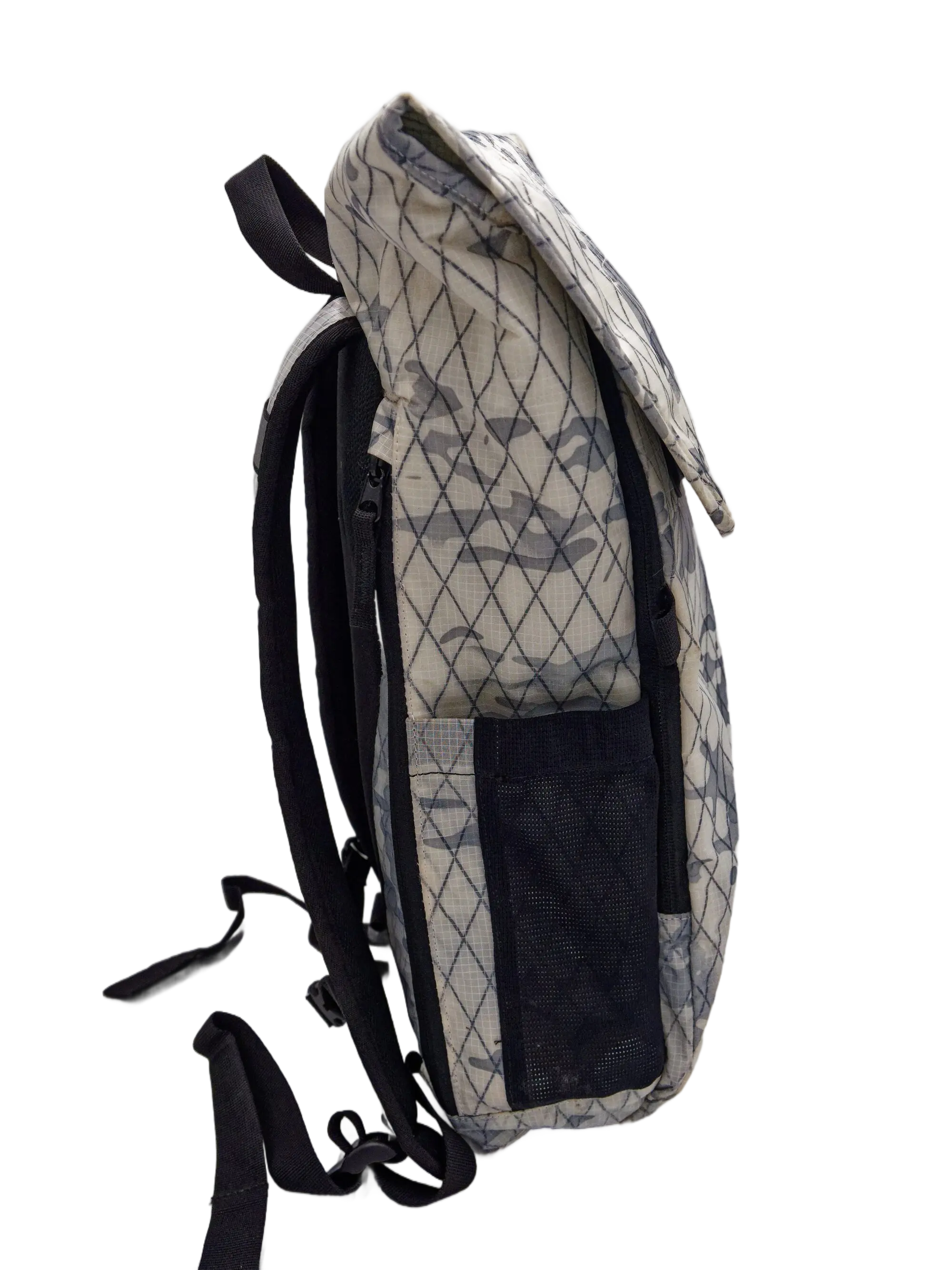 Side view of the camouflage X-Pac backpack showing a black mesh side pocket and black webbing strap hardware