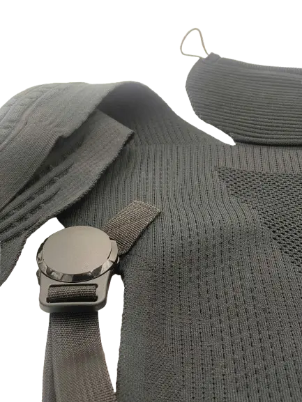 Shoulder strap and magnetic buckle detail of the knitted baby carrier showing the fastening mechanism and ribbed body panel