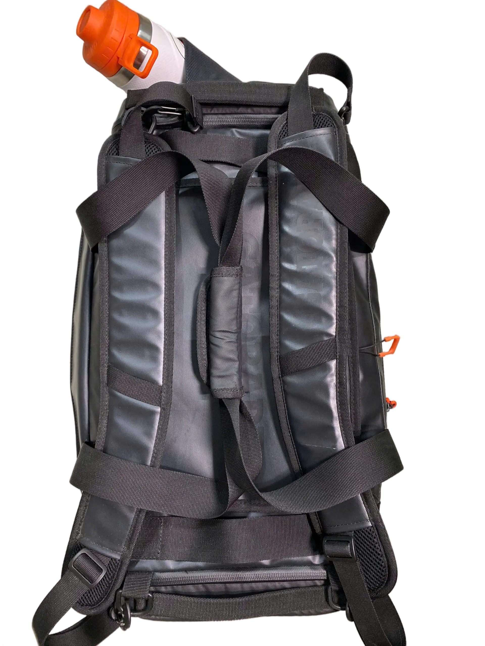 Rear view of the duffle bag worn as a backpack, showing padded black shoulder straps and orange water bottle in the side pocket