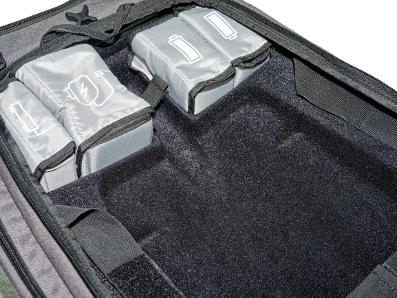 Close-up of the padded interior compartment showing silver battery cases arranged side by side in their dedicated slots