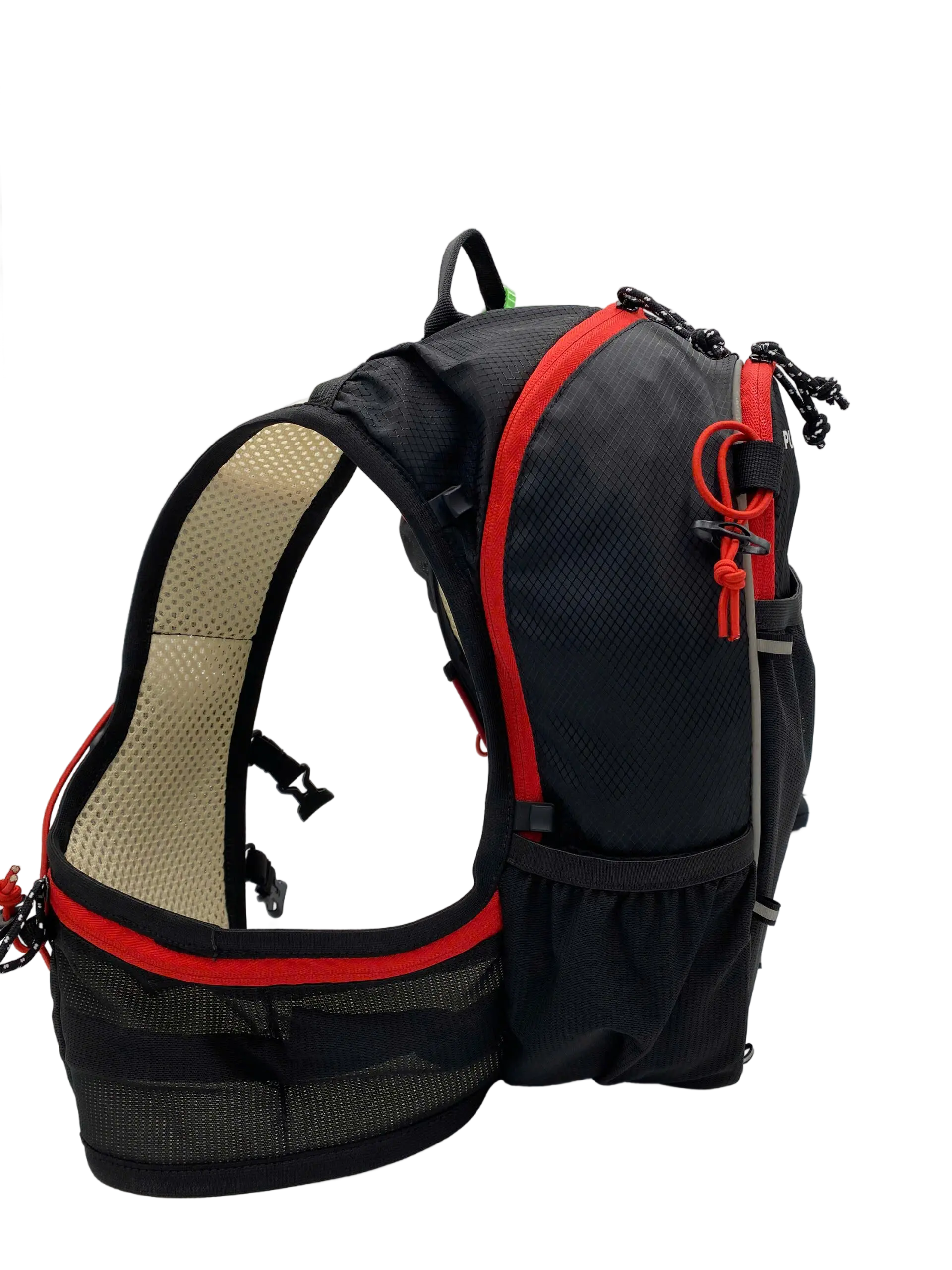 Angled side view of the black trail backpack with red piping, beige mesh shoulder strap and bottom side bottle pocket