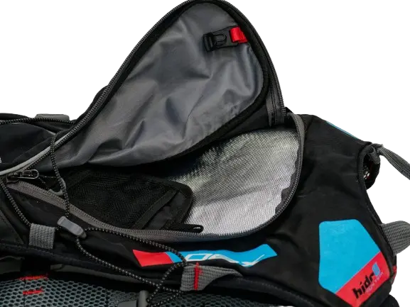 Open hydration compartment showing silver-lined interior, red quick-release buckle and zippered opening