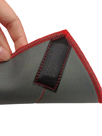 Close-up of the corner hook-and-loop fastener tab on the grey outer face with red contrast stitching and bound edge