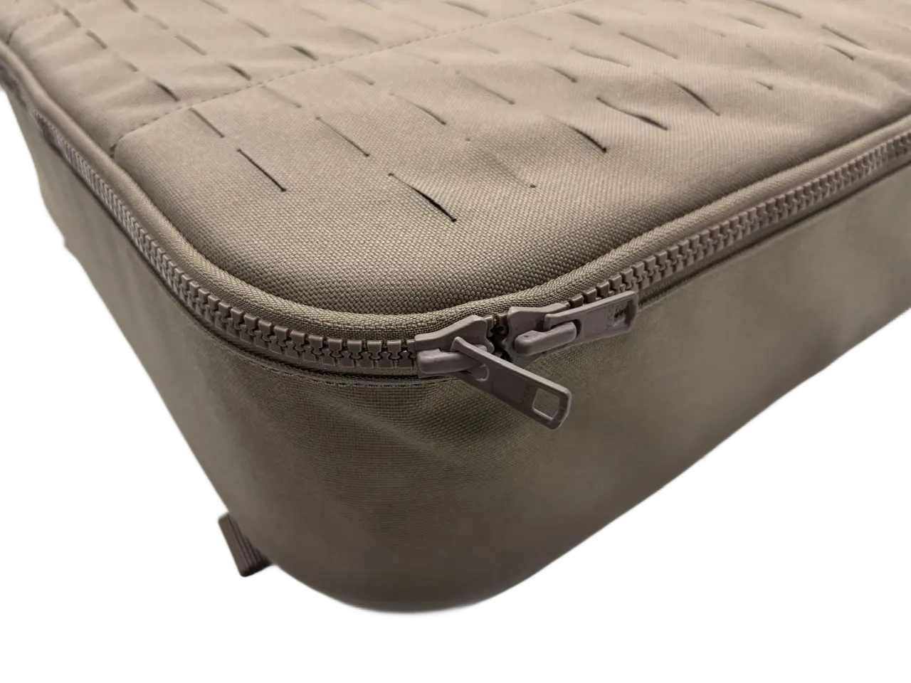 Close-up of the tan nylon drone bag exterior showing laser-cut MOLLE panel and YKK zipper partially open