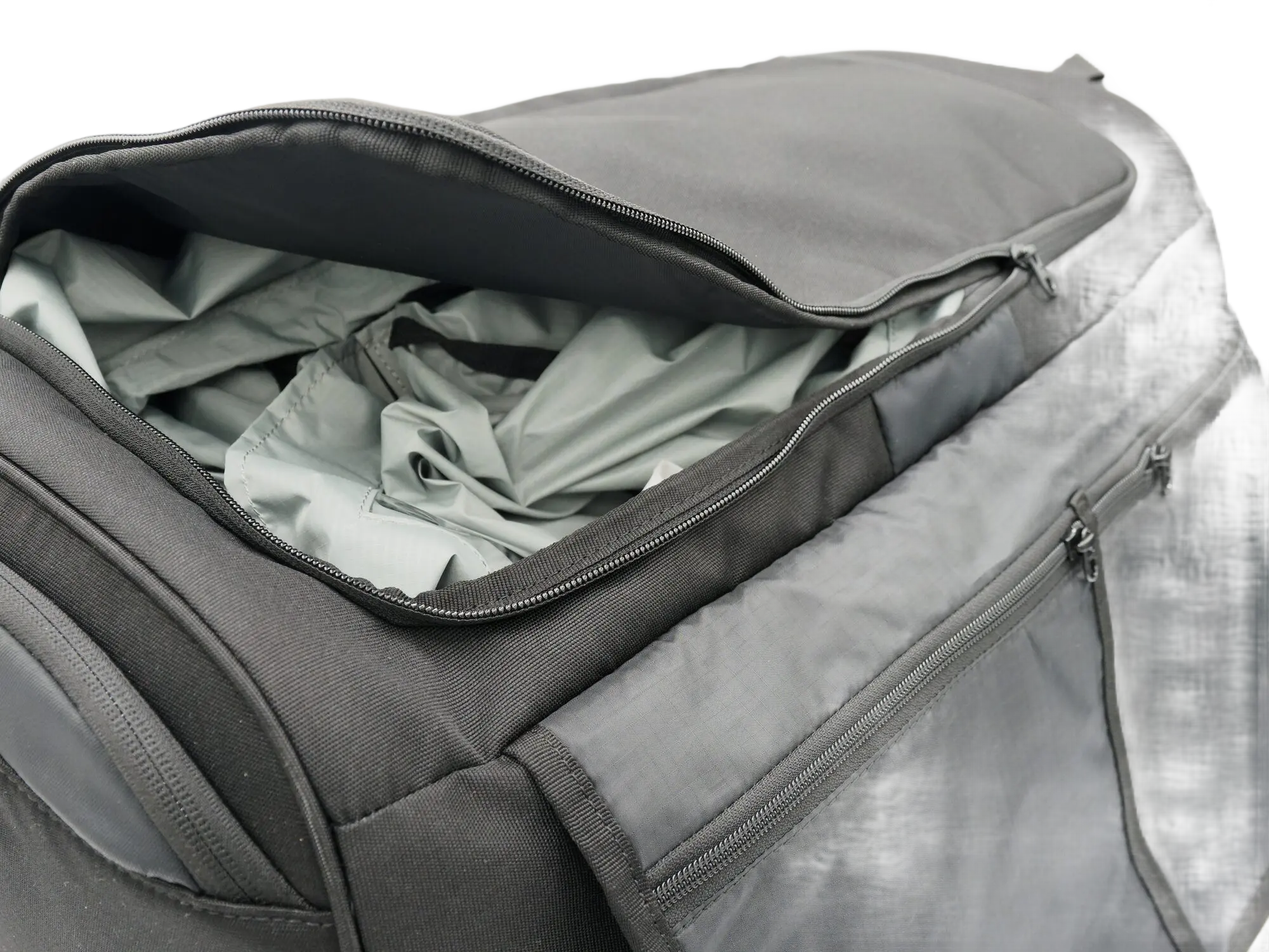 Top view of the open main compartment of the ADV backpack with grey lining and dual-zipper closure visible