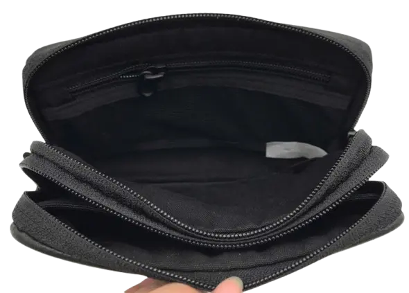 Open dark leather organizer pouch held in hand, showing the fabric-lined interior and internal divider compartment