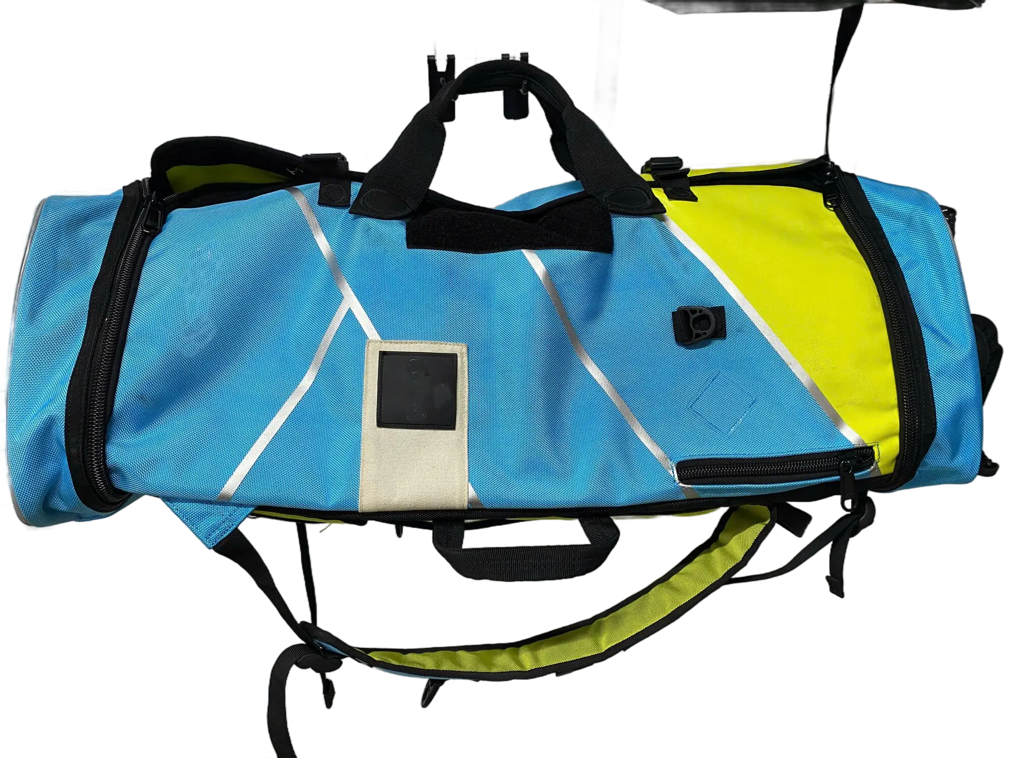 Top-down view of the 54L backpack showing blue and yellow body, ID window patch, and zipper access panel