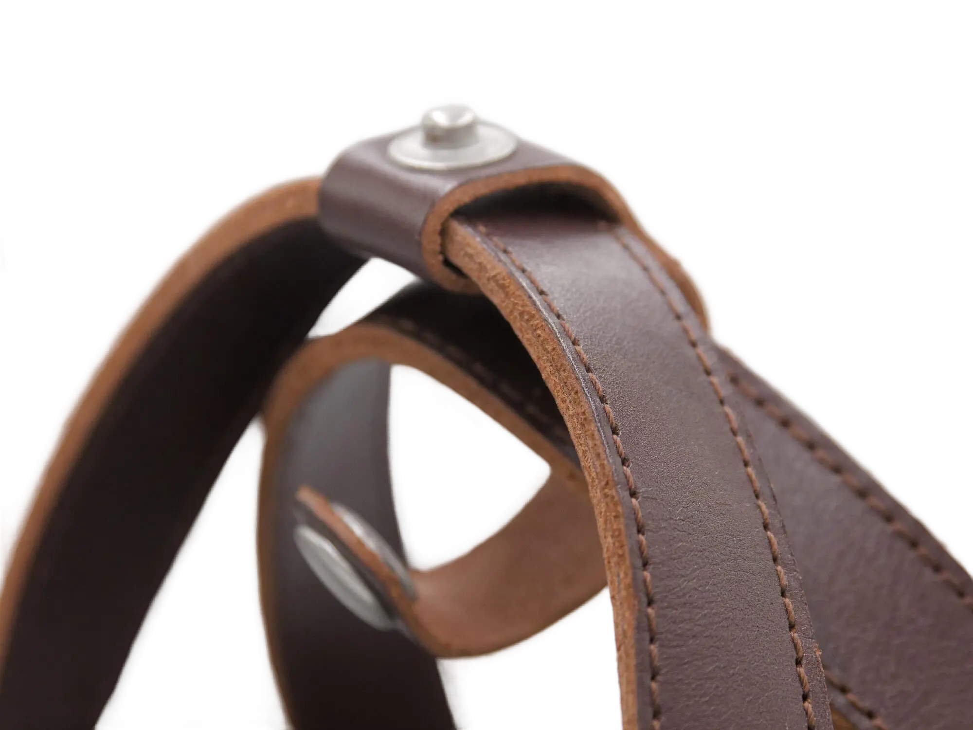 Close-up macro of the brown leather handle loop showing edge stitching, rivet fastener, and leather texture detail