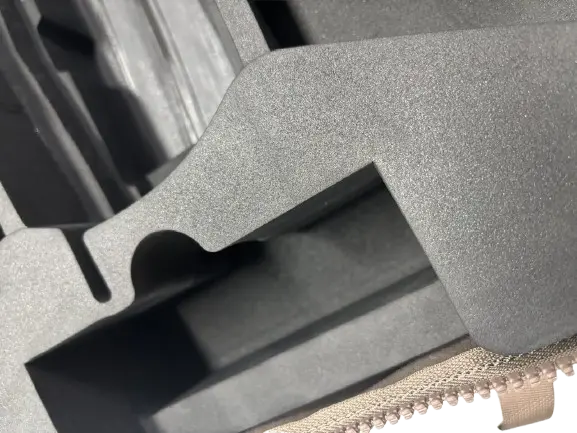 Close-up of grey EVA foam insert showing contoured cavity edges for secure drone component placement
