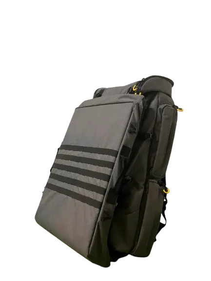 Side view of the closed grey drone carrier with horizontal black MOLLE straps, yellow D-rings, and padded shoulder strap