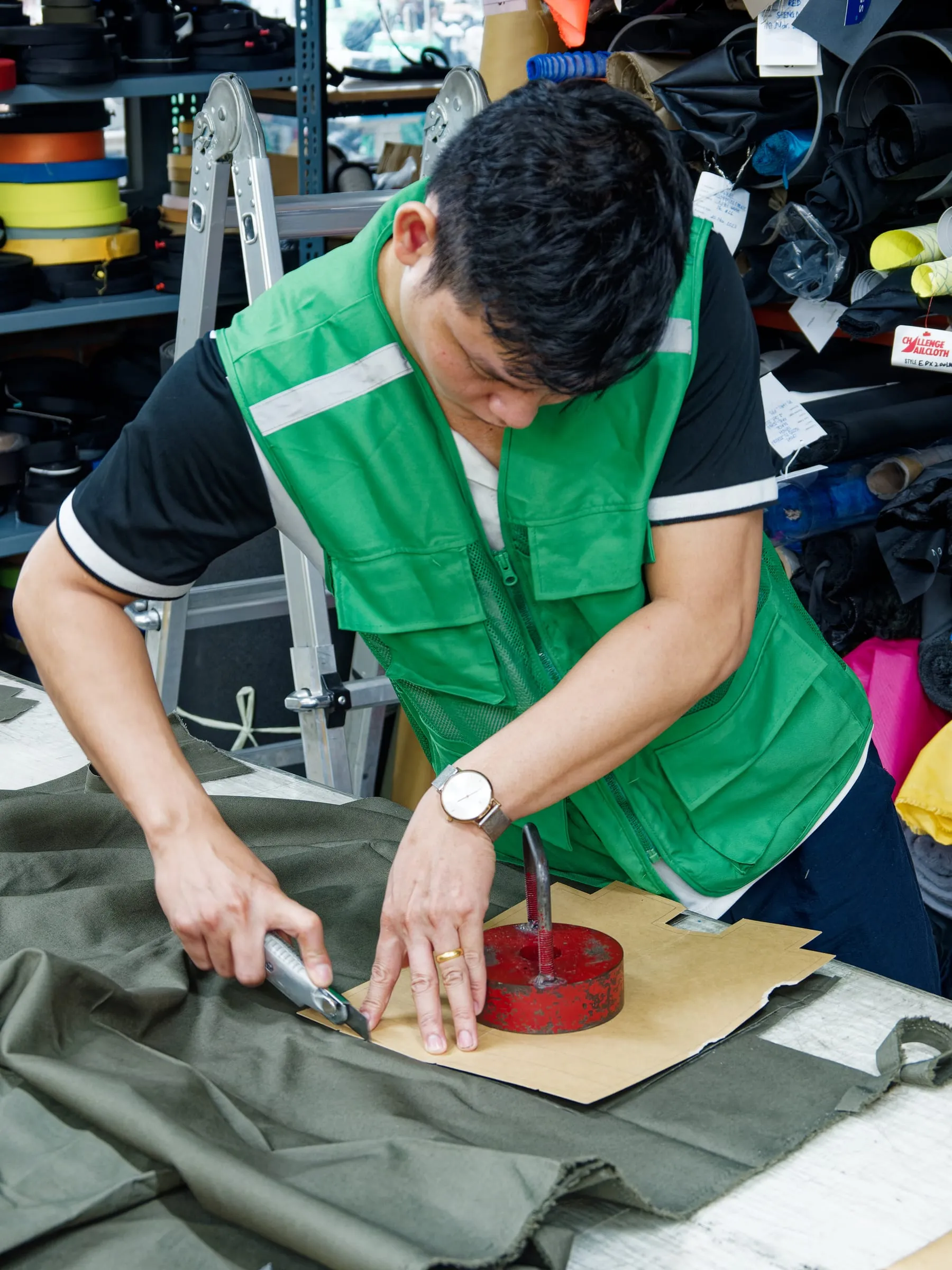 FFG Bags pattern maker cutting fabric around a paper pattern for a prototype sample