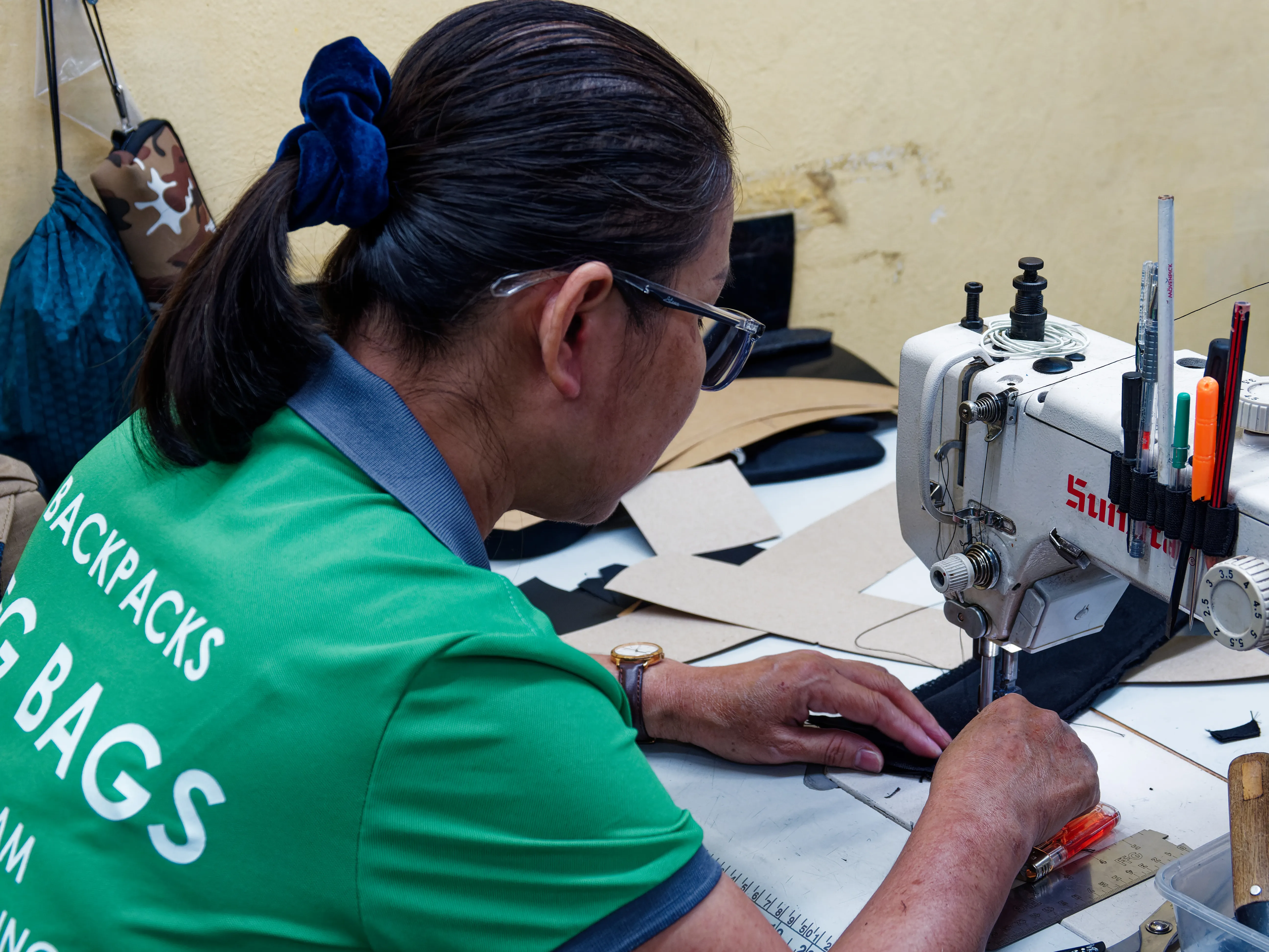 FFG Bags sample maker sewing prototype pieces with paper patterns on the work table