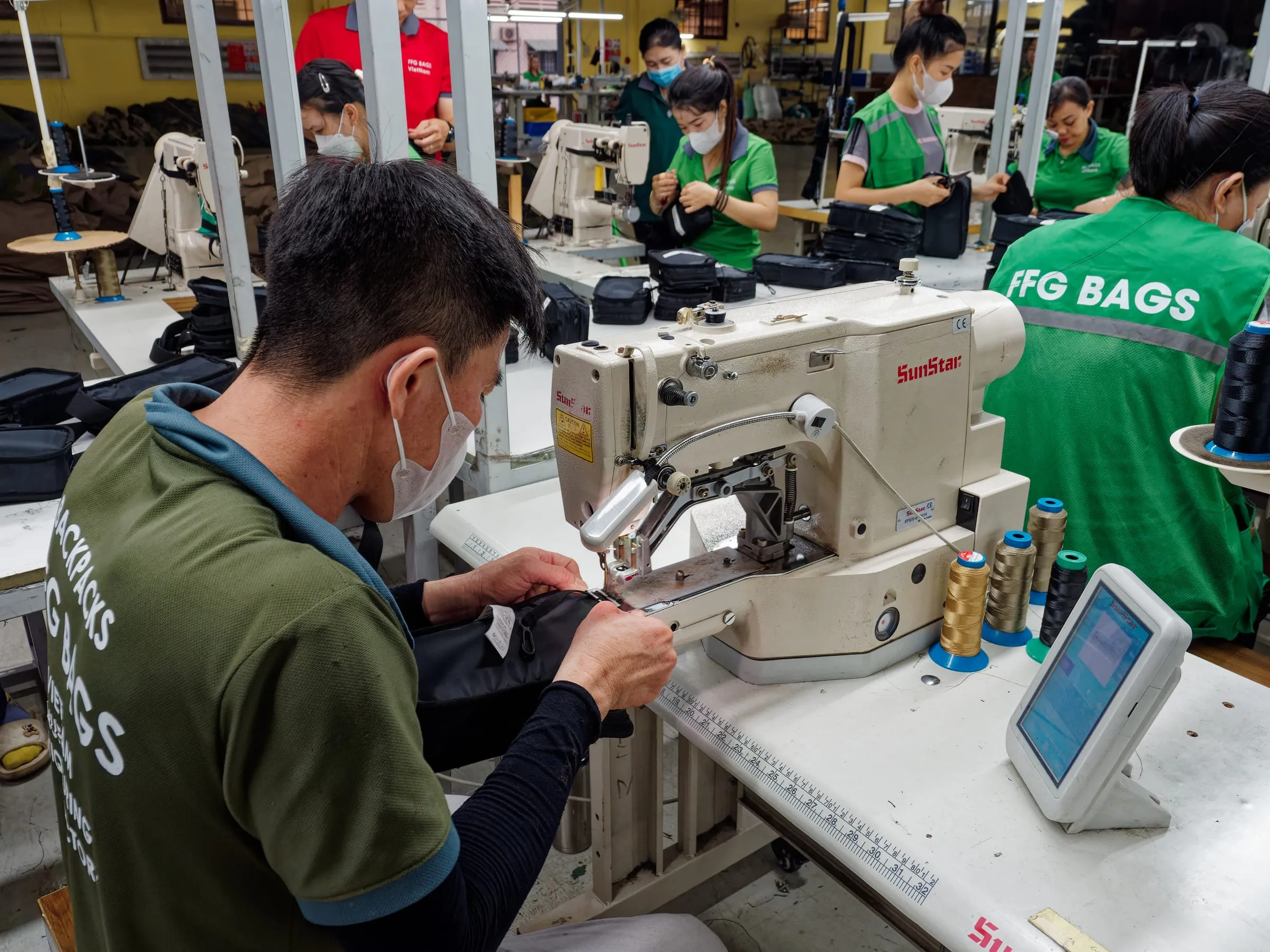 FFG Bags operator sewing a black technical bag on an industrial sewing machine