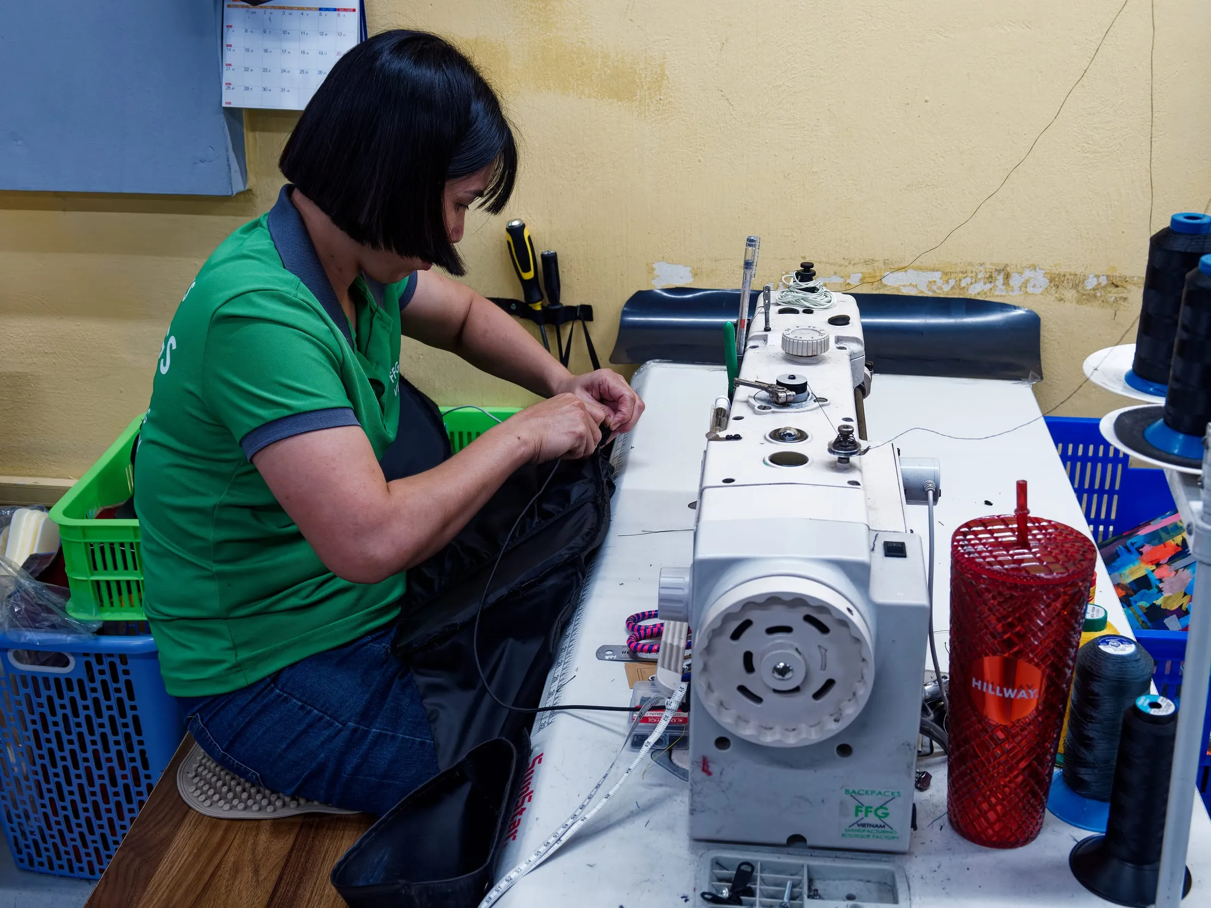 FFG Bags sample maker sewing a black prototype bag at an industrial sewing machine